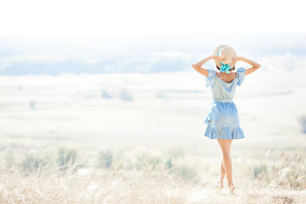 Attraktive junge Frau im Freien vor sommerlichem Hintergrund. Urlaubs- und Erholungskonzept. - Foto, Bild