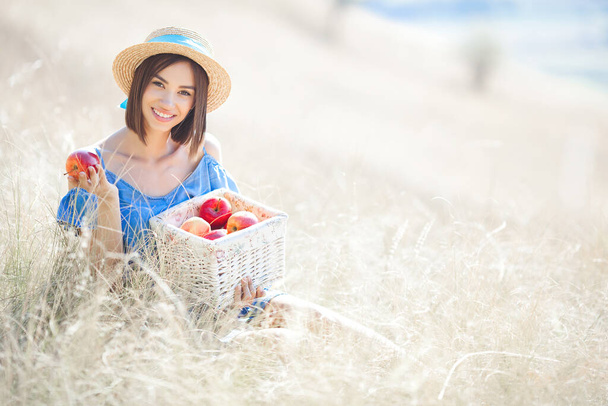 Nette junge Frau mit Äpfeln im Freien. Sommerlicher Hintergrund. - Foto, Bild