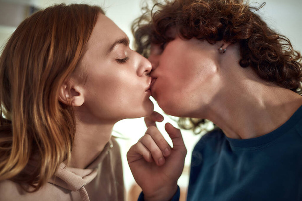 Romantic moment. Close up of young beautiful couple kissing while spending time together at home - Foto, afbeelding
