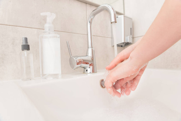Κοντινό πλάνο περικοπή φωτογραφία κυρία πλύνετε τα χέρια νεροχύτη ρεύμα ζεστό νερό ροή σαπούνι τρίψιμο τριάντα δευτερόλεπτα ιική προστασία υγιεινή έννοια στάση ευθύνη μόλυνση συνήθεια μπάνιο σε εσωτερικούς χώρους - Φωτογραφία, εικόνα