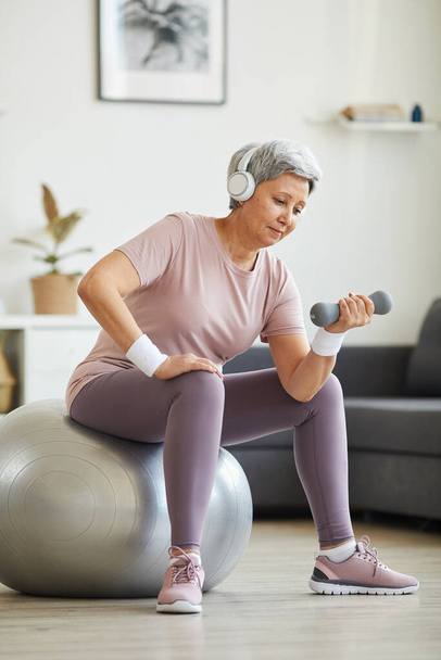 Senior woman exercising with dumbbells - Фото, зображення