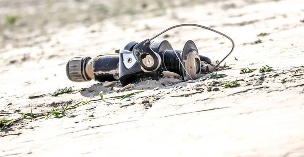 Old fishing spinning reel in the sand - Photo, Image