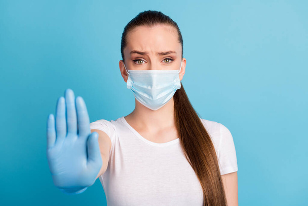 Closeup photo of pretty serious lady keep social distance avoid people contact hospital examination raise arm stand far away wear protect face mask t-shirt isolated blue color background - Foto, immagini