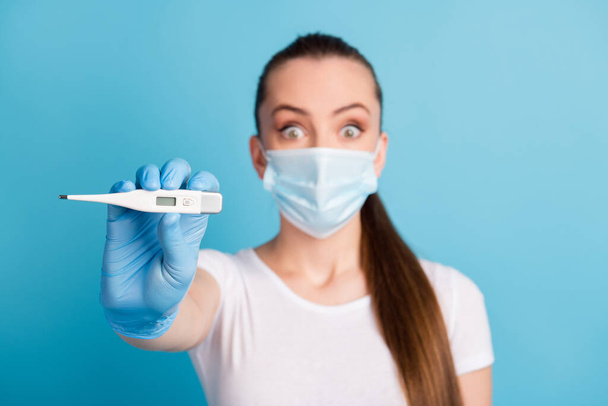 Closeup photo of beautiful shocked fear lady hospital examination thermometer high temperature sick covid wear protect face medical mask white t-shirt isolated blue color background - Fotó, kép