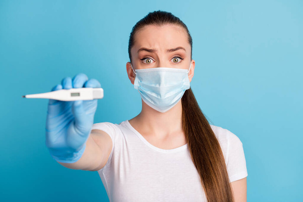 Oh no. Closeup photo of beautiful terrified lady hospital examination doctor hold thermometer high temperature wear protect face medical mask white t-shirt isolated blue color background - Foto, immagini