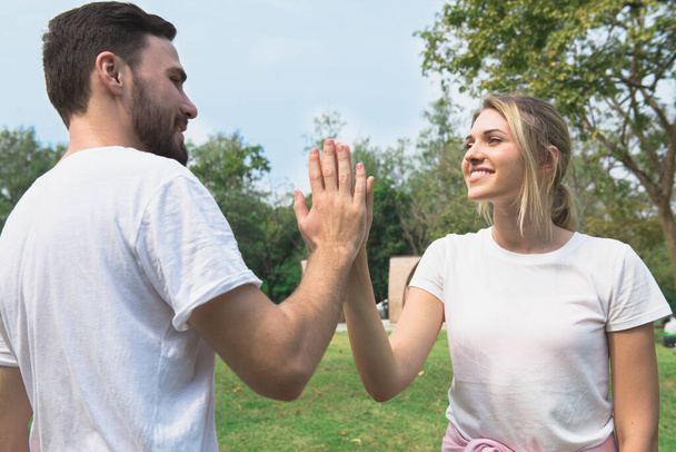 Young couple smile and greet with hi-five when first meet in the garden - Foto, imagen