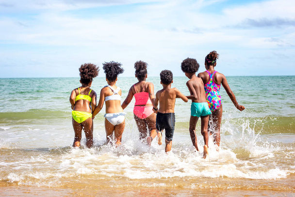 Crianças brincando correndo na areia na praia
 - Foto, Imagem