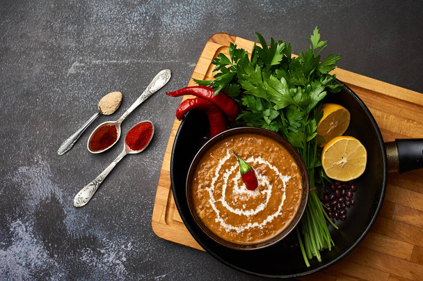 Dal Makhani vor dunklem Hintergrund. Dal Makhani - traditionelles Gericht der indischen Küche mit Urad-Bohnen, roten Bohnen, Butter, Gewürzen und Sahne. - Foto, Bild