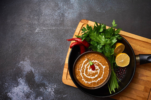 Dal Makhani at dark background. Dal Makhani - traditional indian cuisine puree dish with urad beans, red beans, butter, spices and cream. Copy space - Foto, Bild