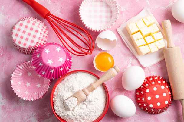 Baking or cooking background. Ingredients for baking cakes or muffins. Kitchen utensils, flour, eggs, butter. Flat lay, top view - Photo, Image