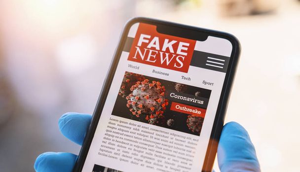 Online Corona Fake news on a mobile phone. Close up, man reading Fake news or articles about covid-19 in a smartphone screen application. Hand with gloves holding smart device. COVID19 nCov Outbreak. - Photo, Image