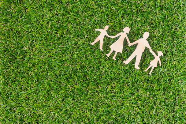 Деревянная семья на зеленой траве. Зеленая семья
. - Фото, изображение