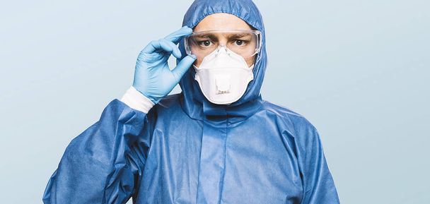 Doctor wearing protection Suit for Fighting Covid-19 (Corona virus) SARS infection Protective Equipment (PPE) with N95 or ffp3 mask. - 写真・画像