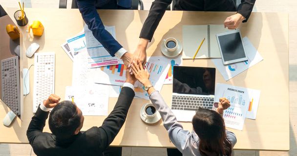 Business Team Stacking Hands At Conference Table. High angle view of business team stacking hands at conference table in board room. Horizontal shot. - Photo, Image