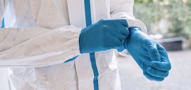 opiekun noszący medyczne rękawice lateksowe w pracy zapobiegające zakażeniu koroną COVID-19 i SARS podczas pandemii koronawirusowej - Zdjęcie, obraz