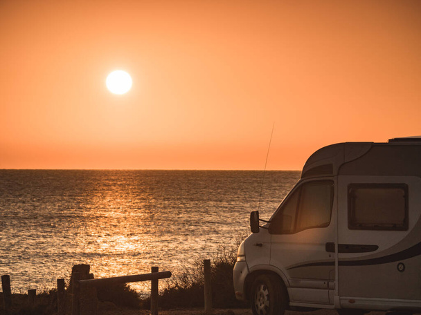 Camper recreational vehicle at sunrise on mediterranean coast in Spain. Camping on nature beach. Vacation and traveling in motor home. - Foto, immagini