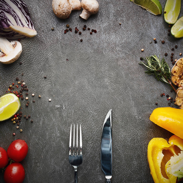 food background. raw vegetable ingredients with cutlery around grey stone background. free space for text. Frame of organic food. - Фото, зображення