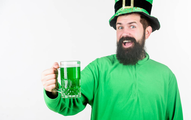 Celebrando el día de San Patricio. Un hombre barbudo brindando por el día de San Patricio. Hipster en sombrero de duende sosteniendo taza de cerveza. Un irlandés con barba bebiendo cerveza verde. Hay un poco de irlandés en mí - Foto, imagen