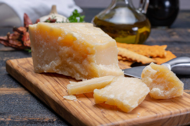 Comida tradicional italiana - 36 meses de idade em grutas de queijo duro parmesão italiano de Parmigiano-Reggiano, Itália
 - Foto, Imagem