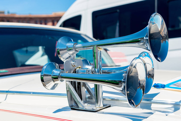 A close-up view of a chrome horn on the hood of a car - Photo, Image