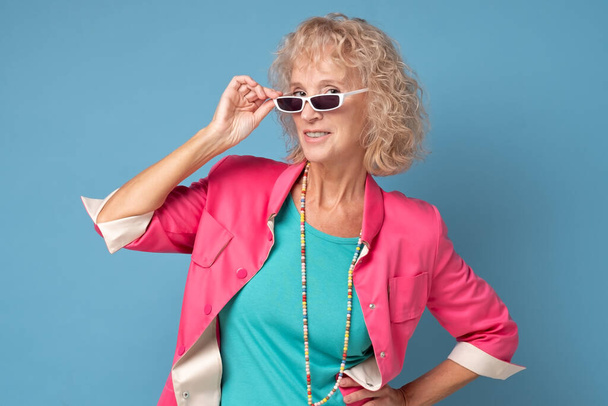 Beautiful and happy blond grandma looking at camera through summer glasses. - Foto, Imagem