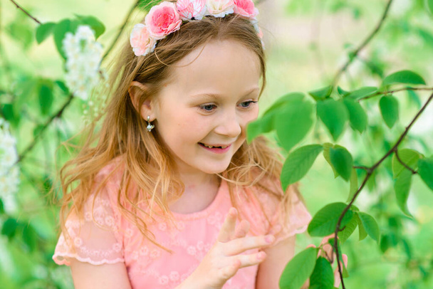 Outdoor portrait of cute little girl in princess dress. Blooming garden, emotional photo - Photo, Image