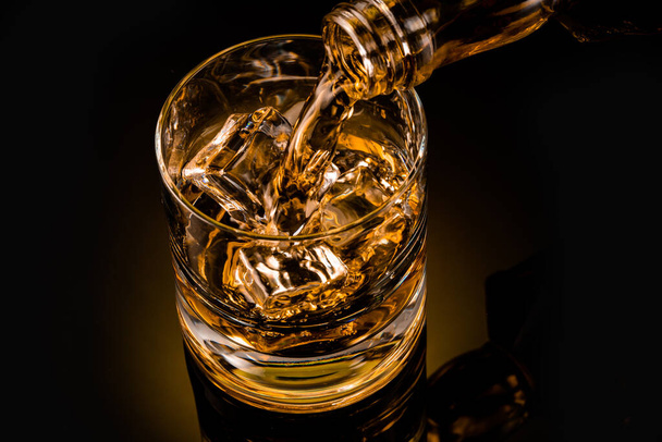 vaso de whisky sobre fondo negro - Foto, Imagen