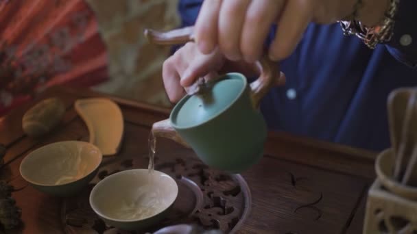 Ο άνθρωπος ρίχνει πράσινο τσάι από τσαγιέρα σε Gaiwan στην παραδοσιακή κινεζική τελετή τσαγιού. - Πλάνα, βίντεο