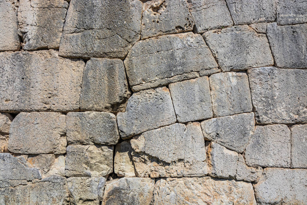 Die antiken megalithischen Mauern umgeben die Akropolis von Amelia in Umbrien, Italien. Struktur aus riesigen Steinblöcken, mit unregelmäßigen Felsbrocken, die ineinander greifen. - Foto, Bild