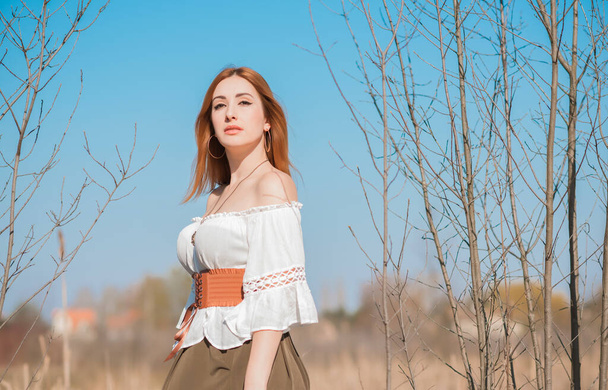 Aspecto de la naturaleza, Estilo medieval de ropa, mujer pelirroja en blusa vintage de algodón, cinturón y falda
 - Foto, Imagen
