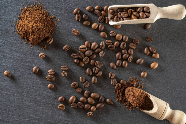 カフェコーヒーの背景。食品用エスプレッソ豆,黒でカフェインの朝食を飲む.エネルギーモカ、カプチーノ成分のために隔離された茶色のローストコーヒーの種。コピースペース,トップビュー. - 写真・画像