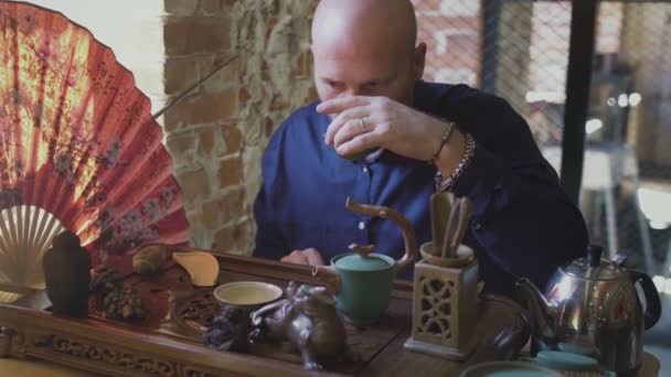 Homem está bebendo chá verde de Gaiwan
 - Filmagem, Vídeo