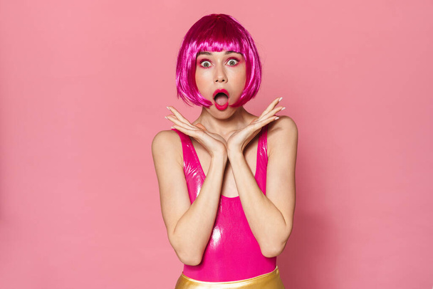Image of shocked beautiful woman in wig expressing surprise at camera isolated over pink background - Фото, зображення