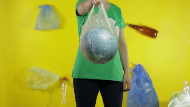 Αγνώριστη γυναίκα με γήινη σφαίρα σε πλαστικό πακέτο. Σώσε την οικολογία Πλαστική ρύπανση της φύσης - Πλάνα, βίντεο