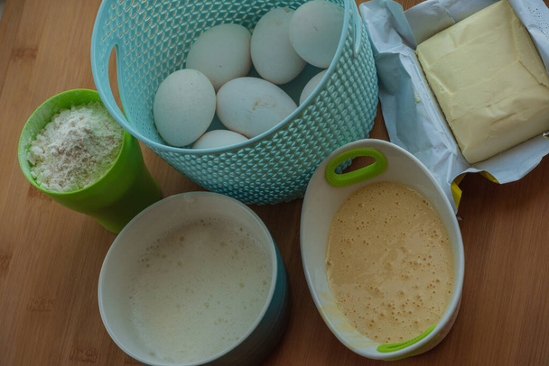 Przygotowanie do pieczenia masła z mąki. Bite jajka oddzielnie białka i żółtka, mąka, masło. Składniki ciasta do pieczenia. - Zdjęcie, obraz