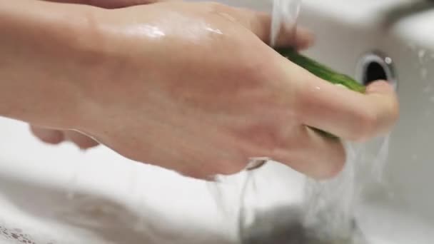 Die Gurke unter fließendem Wasser mit der Hand waschen. Gesunde Ernährung. - Filmmaterial, Video
