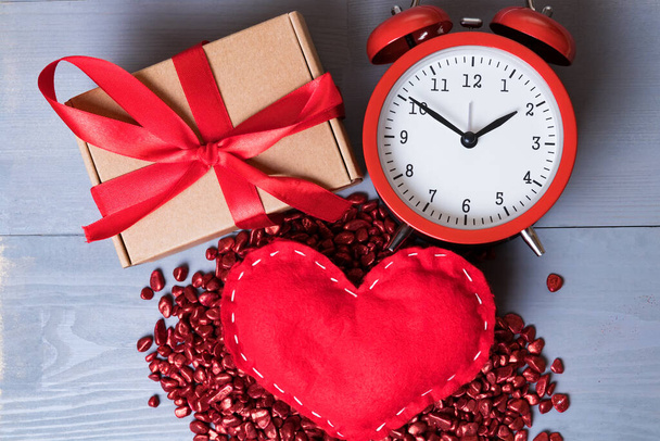 Czerwone domowe serce z prezentem lub prezentem i zabytkowy zegar w Walentynki. Czas na miłość lub romans abstrakcyjna koncepcja. - Zdjęcie, obraz