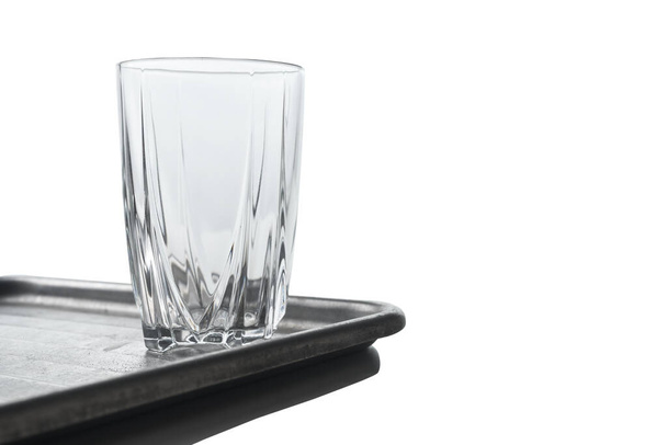 Copo de vidro com padrão de vida tranquila em uma bandeja de prata isolada no fundo branco
. - Foto, Imagem