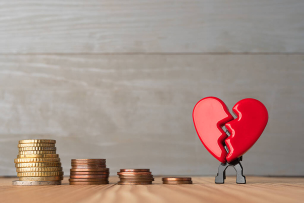 Zlomený červený Valentýn srdce s klesající hromady euromincí. Láska a finanční problémy abstraktní koncept. - Fotografie, Obrázek