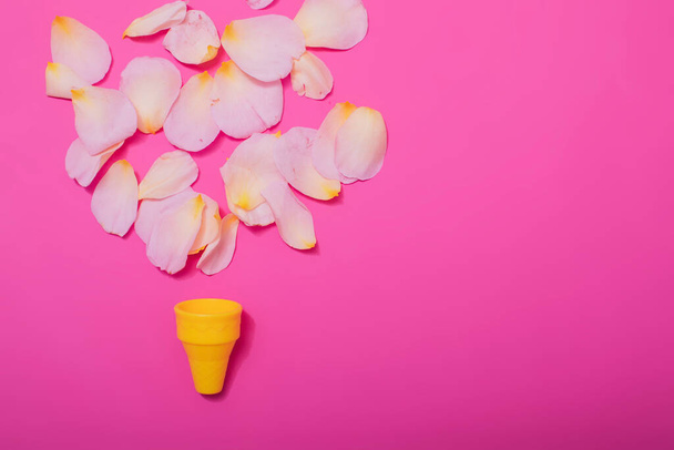 Concepto mínimo de verano. Cono de helado con hojas de rosa sobre un fondo pastel punzante. Acostado. Vista superior. Diseño creativo
. - Foto, Imagen