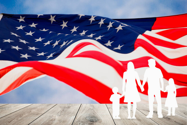 Család az Egyesült Államokban, papírfigurák koncepciója. Emberek vagy család papír alakú zászlóval az Amerikai Egyesült Államok. A veteránok ünnepe, emléknap, függetlenség és munka ünnepe - Fotó, kép