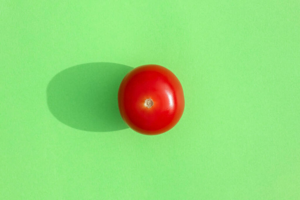 tomato with a hard shadow on a colored background pattern - Foto, afbeelding