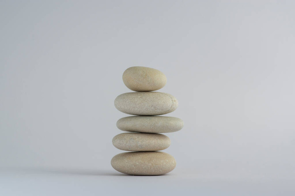 One simplicity stones cairn isolated on white background, group of five white pebbles in tower, harmony and balance - Zdjęcie, obraz