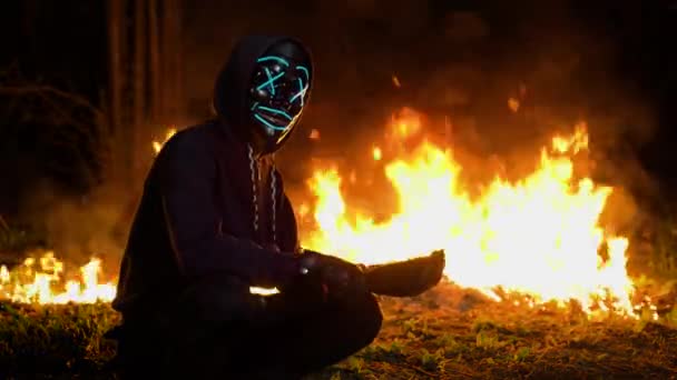Чоловік у масці з бейсбольною битою на задньому плані вогню. Вогонь повертається - Кадри, відео