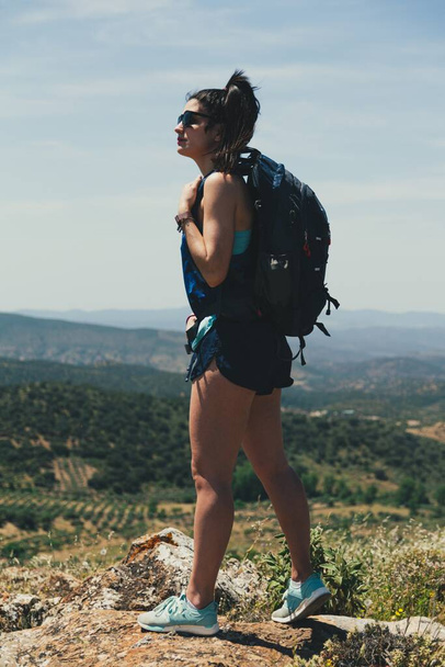 山のハイキングでバックパックを持つ若い女性の後部ビュー｜トレッキング. - 写真・画像