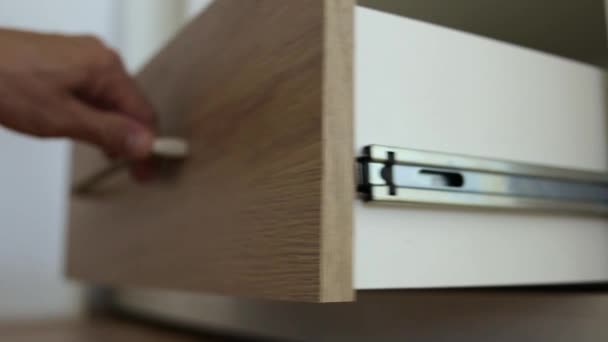 Primer plano de manos de carpintero masculino ensamblando mueble armario e instalando cajón nuevo de madera. - Metraje, vídeo