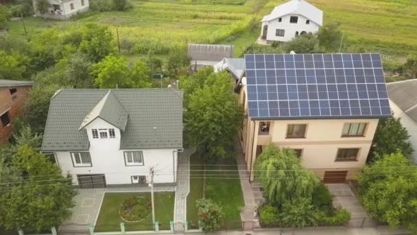屋根の上に青色の光沢のある太陽光発電パネルシステムと新しい近代的な住宅のコテージの空中トップビュー。再生可能エネルギーグリーンエネルギー生産コンセプト. - 映像、動画