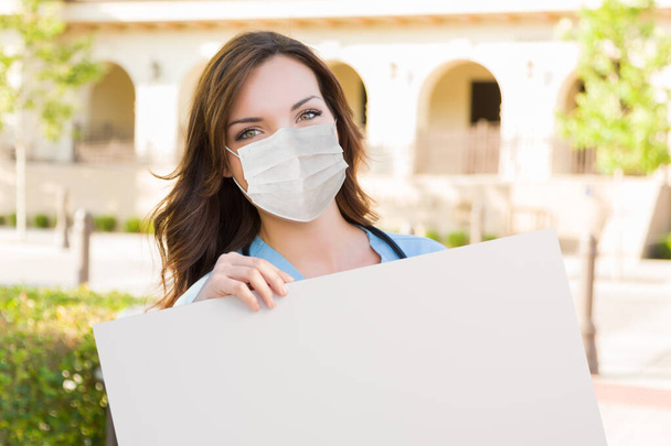 Female Doctor or Nurse Wearing Protective Face Mask Holding Blank Sign. - Φωτογραφία, εικόνα