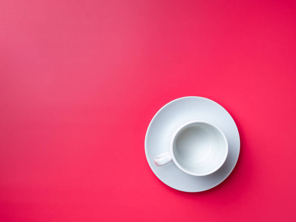 Flat lay. Empty white cup on a saucer on a pink background. Copy space - Foto, Bild