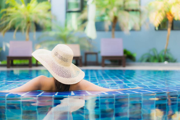 Portret piękna młoda Azjatka relaks wokół basenu w ośrodku hotelowym dla przyjemności na wakacjach - Zdjęcie, obraz